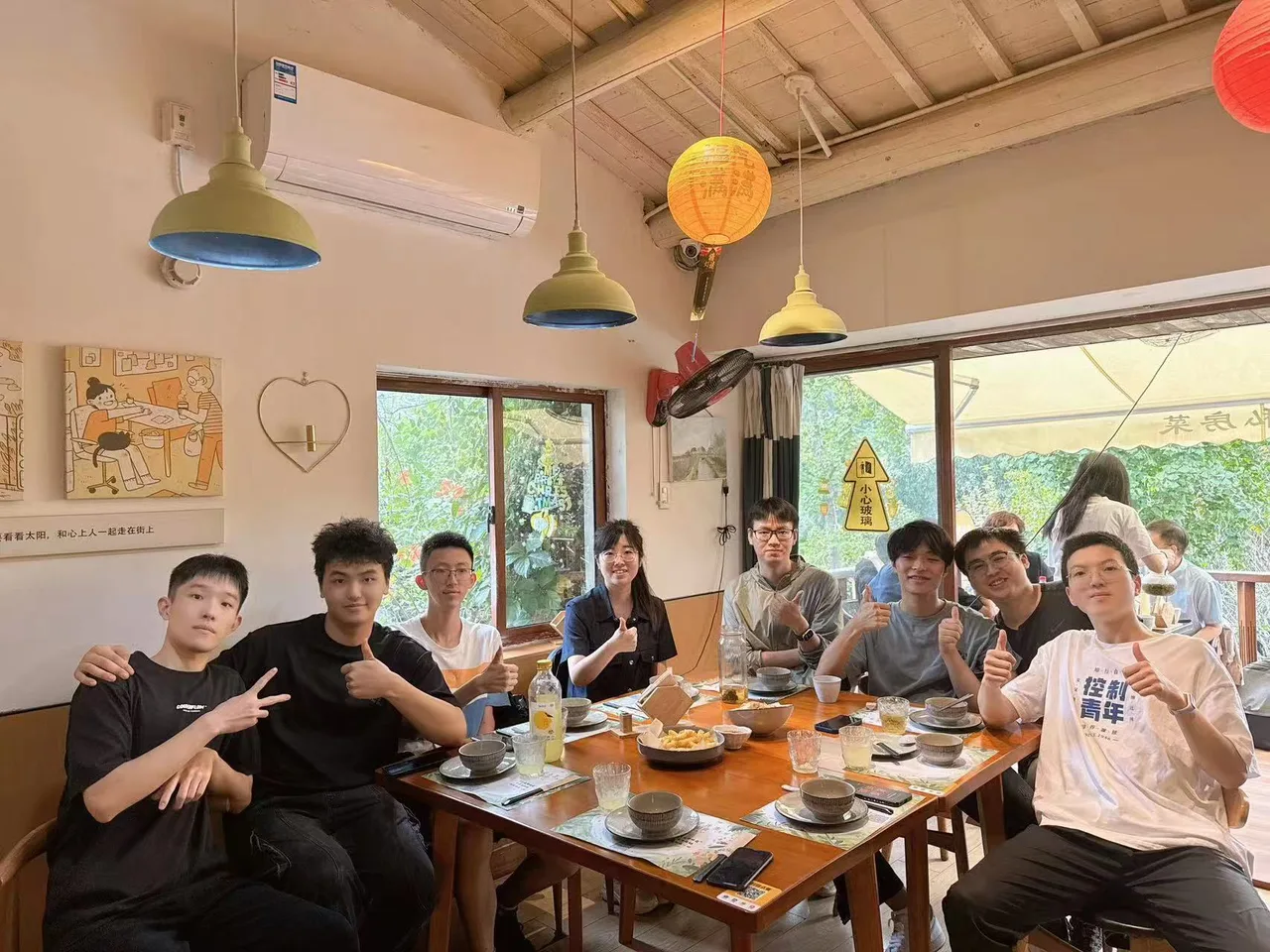 Lab members gathered around a long dinner table in a restaurant, smiling together in a group photo