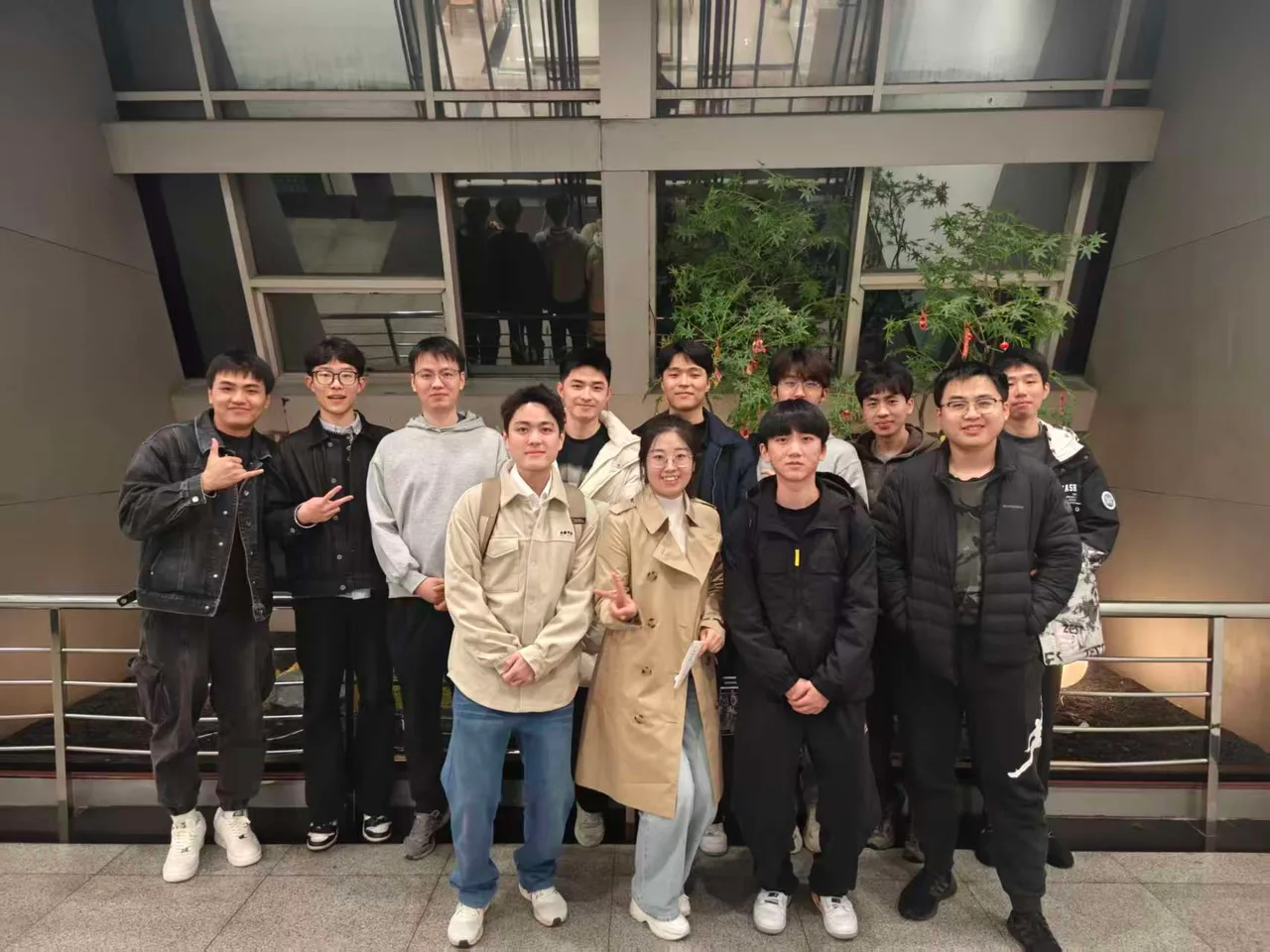 Lab members taking a group photo at a scenic outdoor spot with greenery and a pavilion